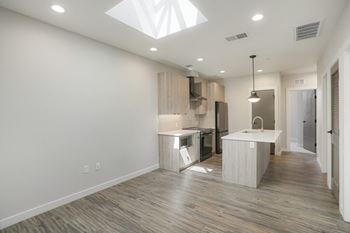 A modern kitchen with wooden floors and white walls.